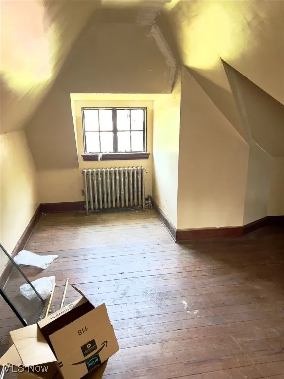 Additional living space possible 5th bedroom wood-type flooring, radiator, and loft ceiling