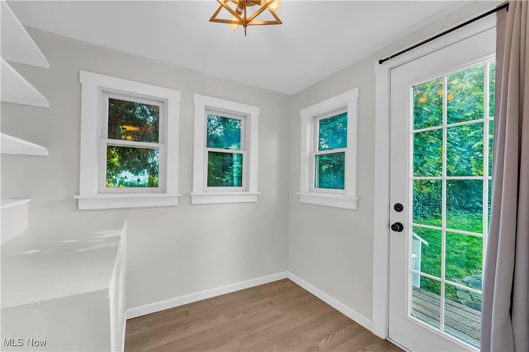 Doorway to outside featuring light wood-style flooring and baseboards