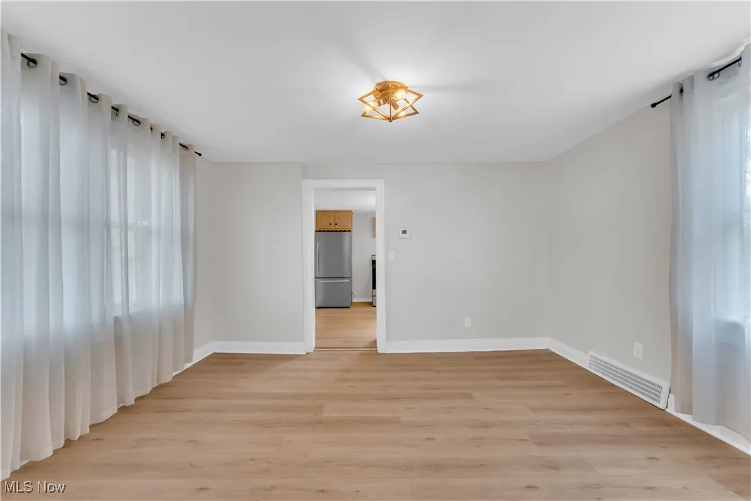 Unfurnished room with light wood-type flooring and baseboards