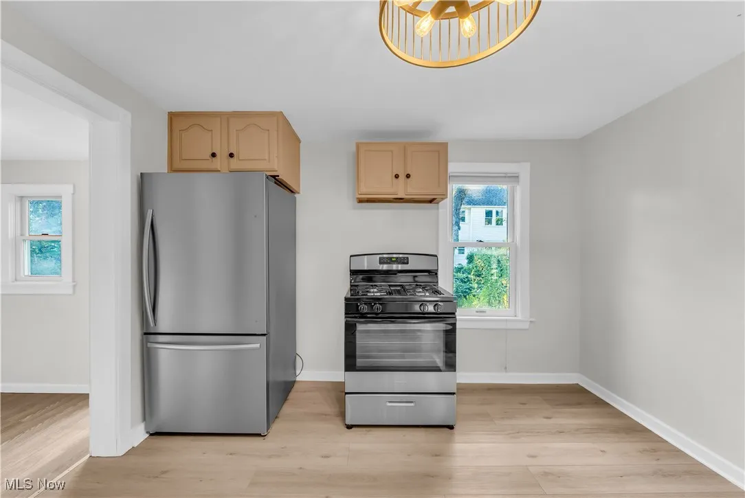 Kitchen featuring appliances with stainless steel finishes, light wood finished floors, and light brown cabinets