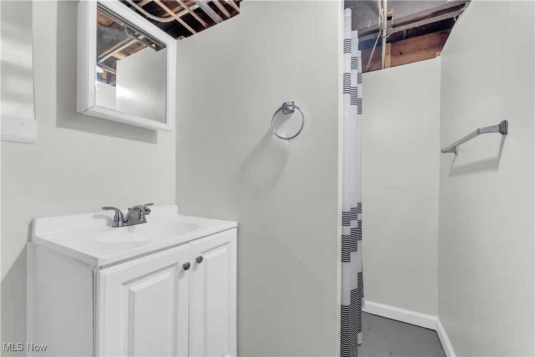Bathroom featuring vanity, a heating unit, and concrete flooring