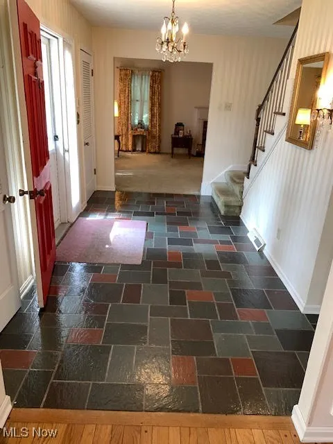 Entryway featuring stairs and a chandelier