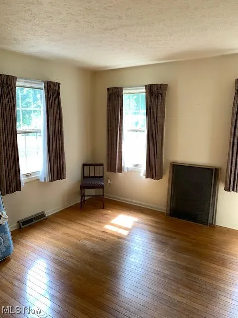 Unfurnished room with a textured ceiling and light wood-style flooring