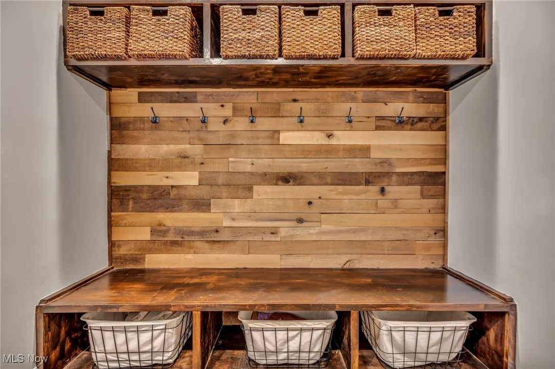 Mudroom featuring wooden walls