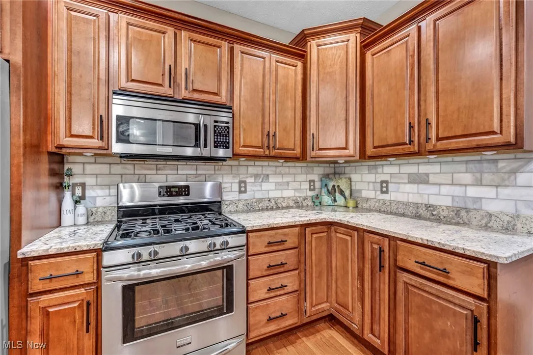 Kitchen featuring stainless steel appliances, light wood-type flooring, and brown cabinetry