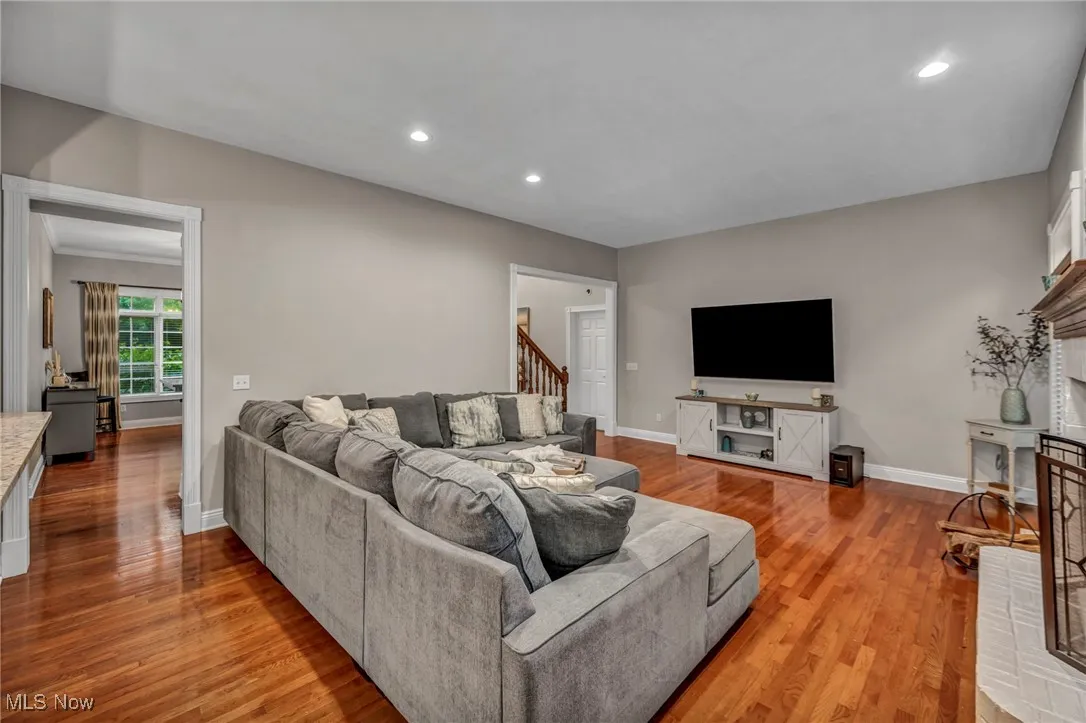 Living room featuring light wood-style flooring, recessed lighting, and stairway