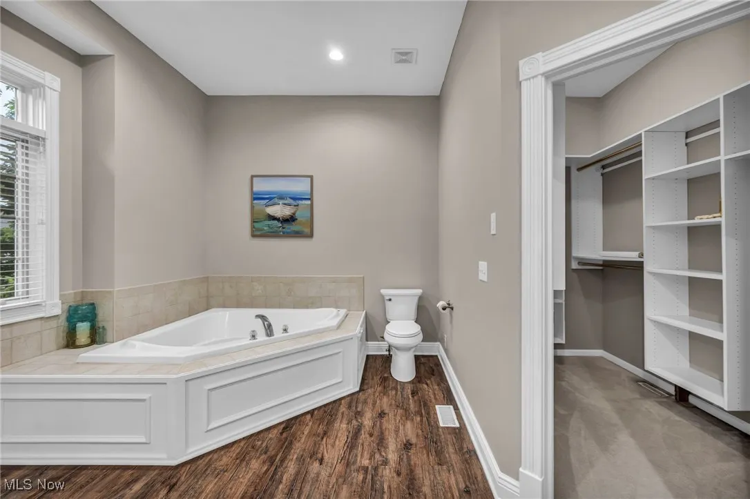 Bathroom with a bath and wood finished floors