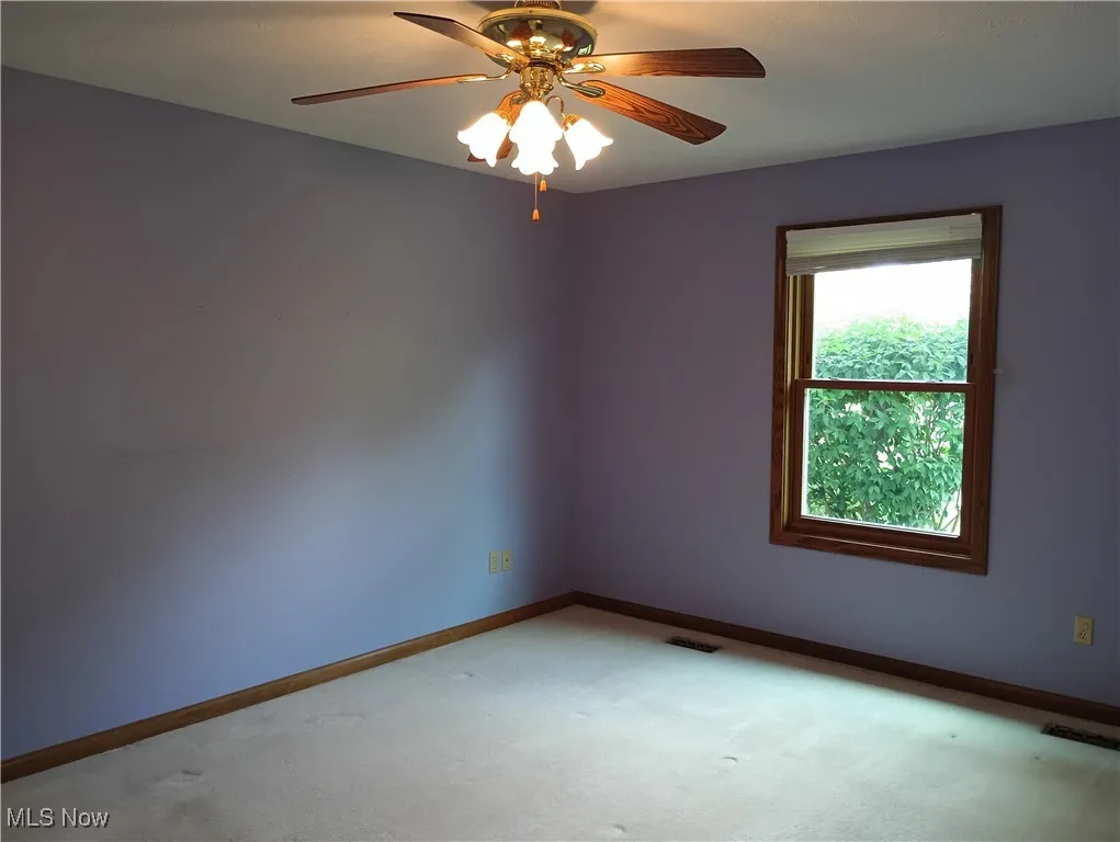 Empty room featuring carpet floors and ceiling fan
