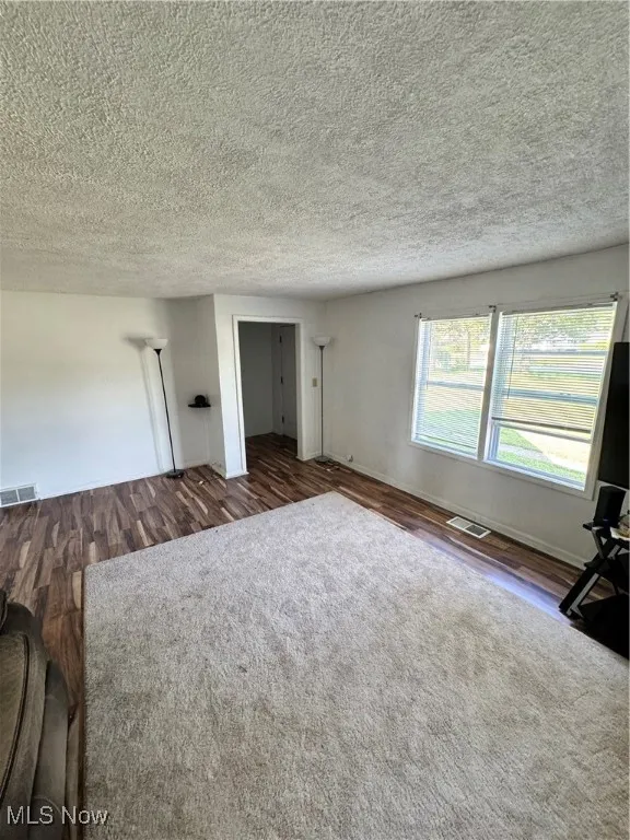 Unfurnished bedroom featuring a textured ceiling and wood finished floors