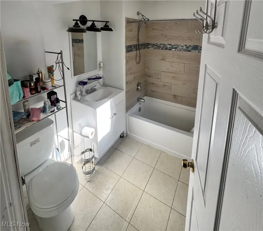 Full bath with shower / tub combination, vanity, and tile patterned floors