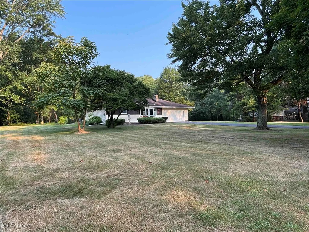 View of green lawn featuring an attached garage