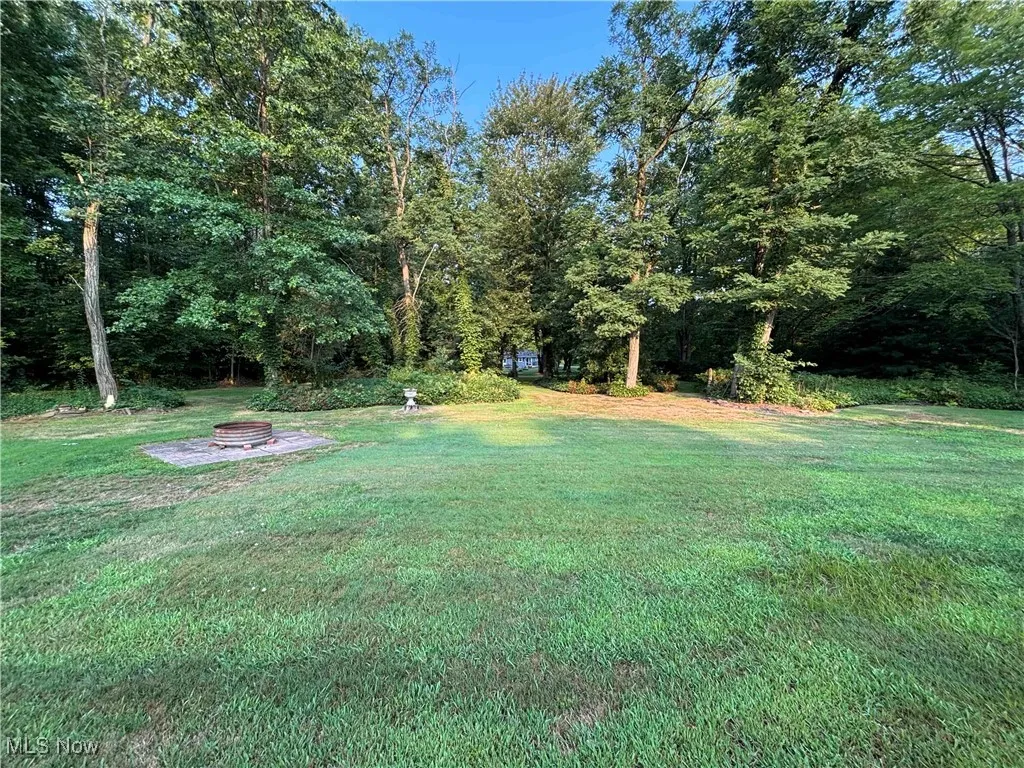 View of grassy yard with a fire pit