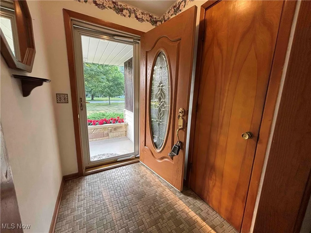 Entryway with brick patterned floors and baseboards