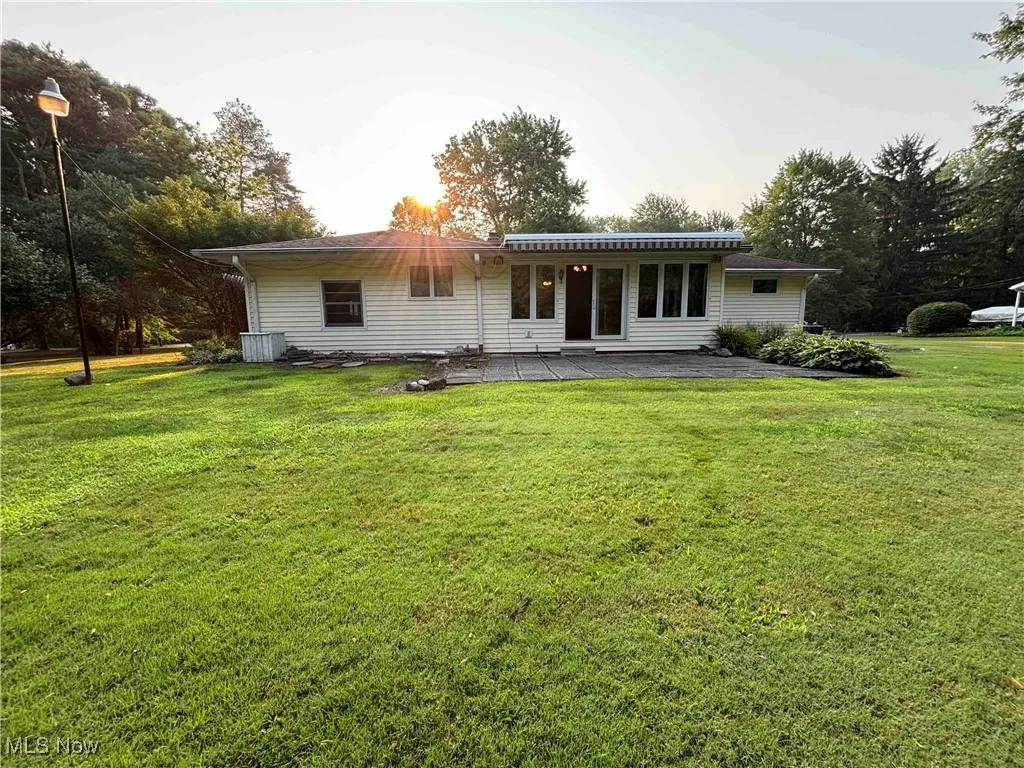 Back of property featuring a yard and a patio area