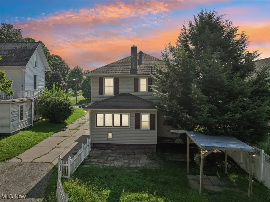 Back of house featuring a chimney, a fenced backyard, and a patio