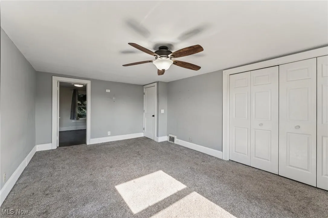 Unfurnished bedroom with carpet flooring, a closet, and a ceiling fan