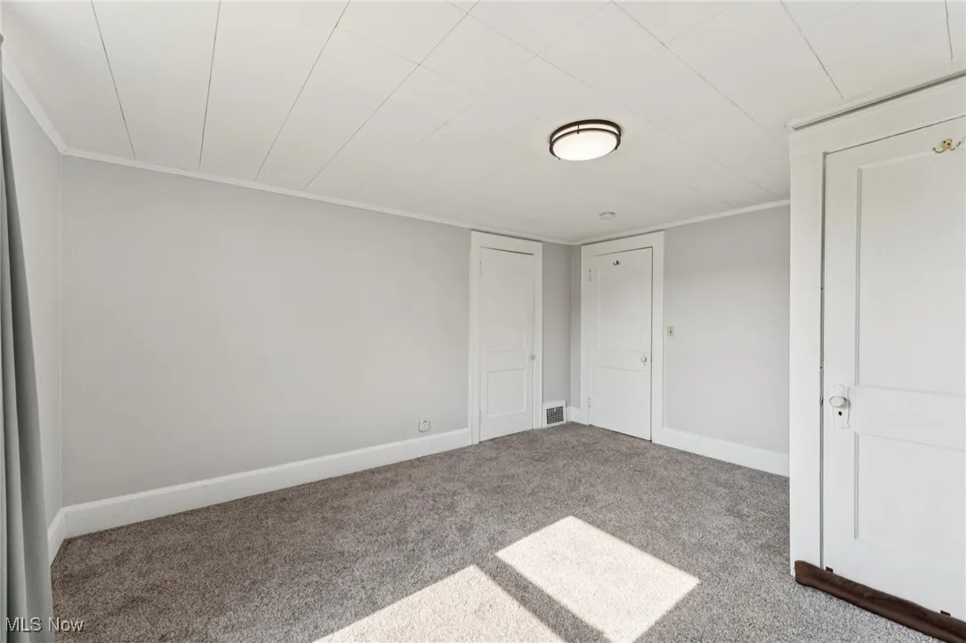 Unfurnished bedroom with carpet and crown molding