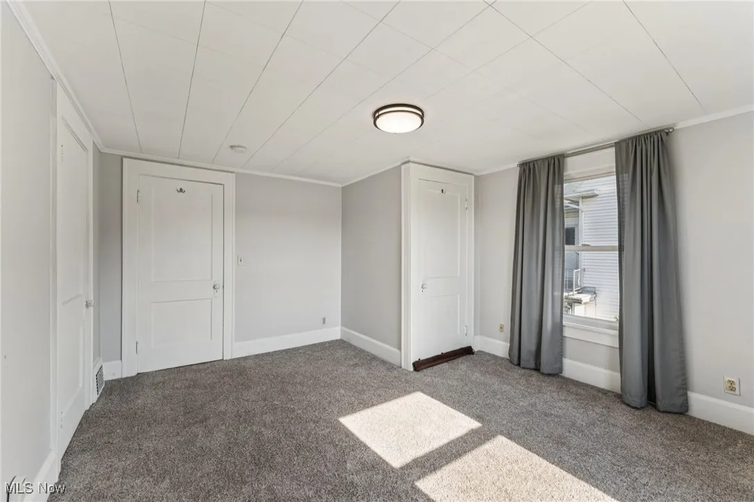 Unfurnished bedroom featuring carpet and ornamental molding