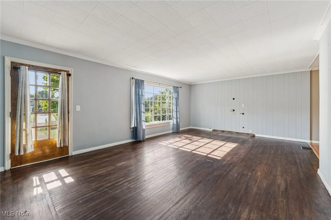 Unfurnished room with wood-type flooring and ornamental molding