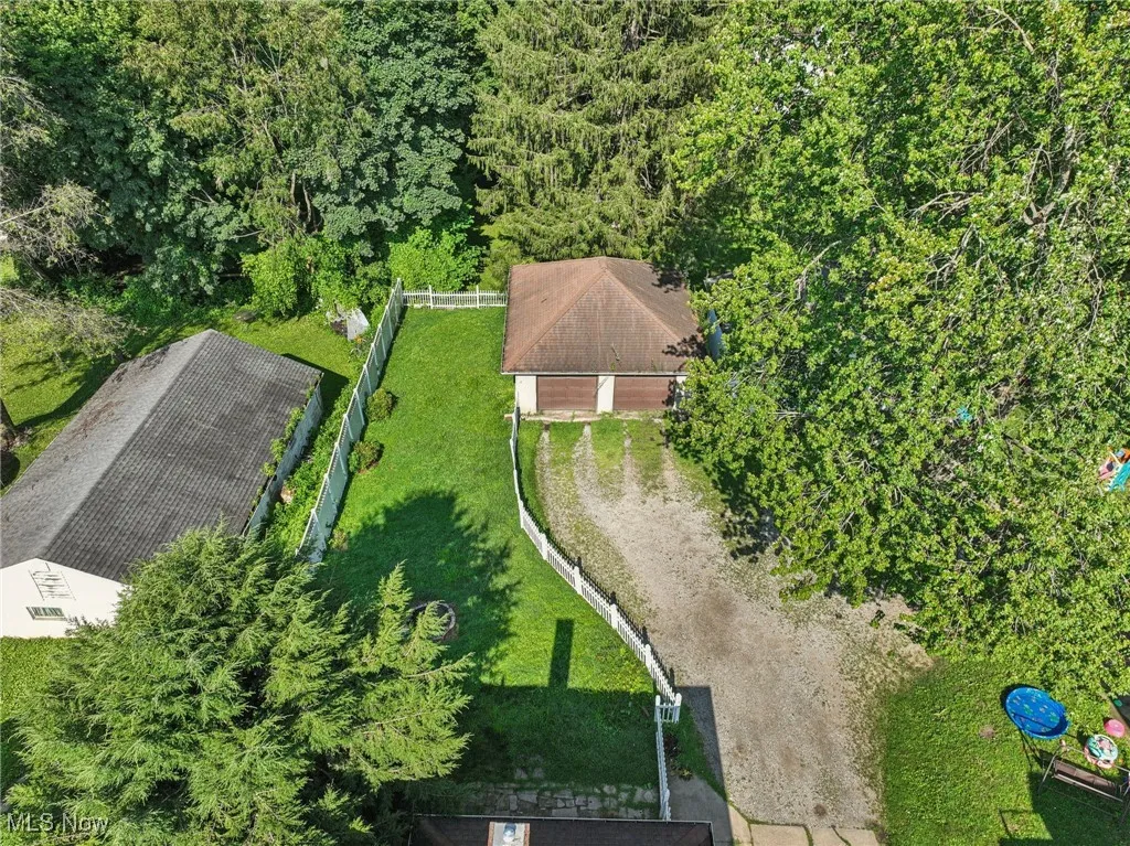 Aerial view of property and surrounding area with a forest