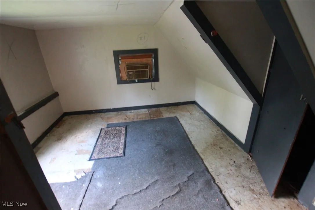 Additional living space featuring baseboards and lofted ceiling