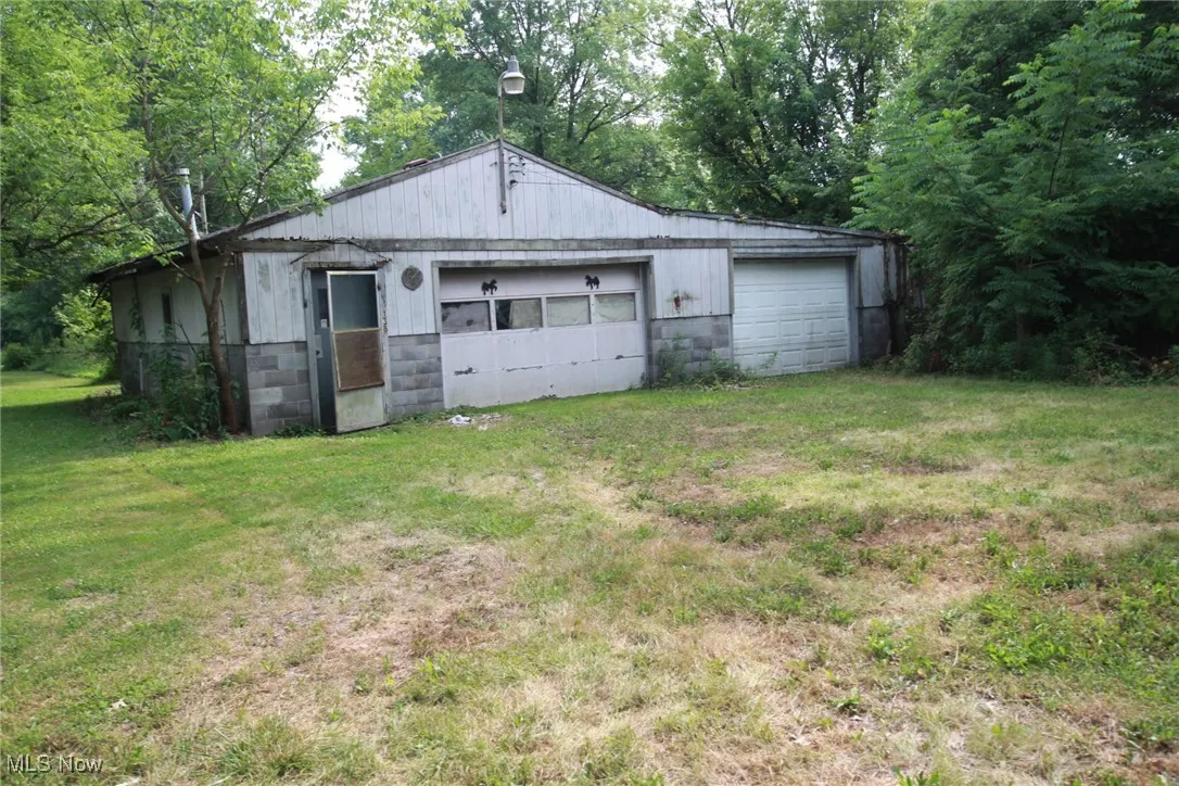 Detached garage with view of scattered trees