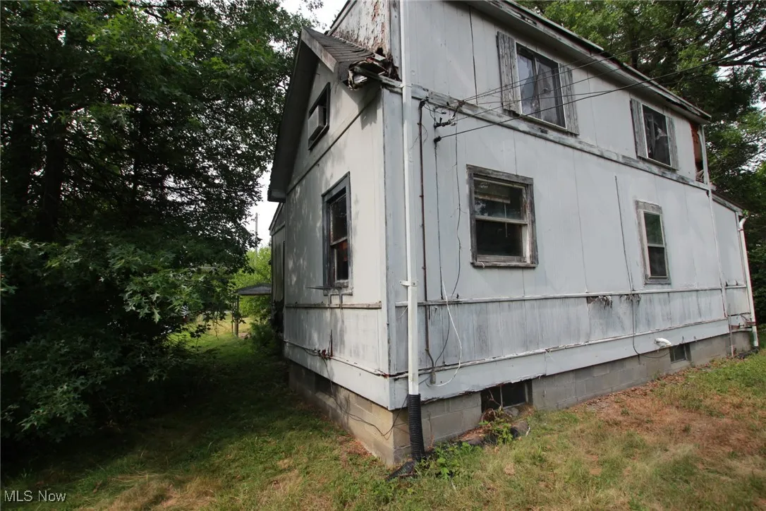 View of property exterior with crawl space and a yard