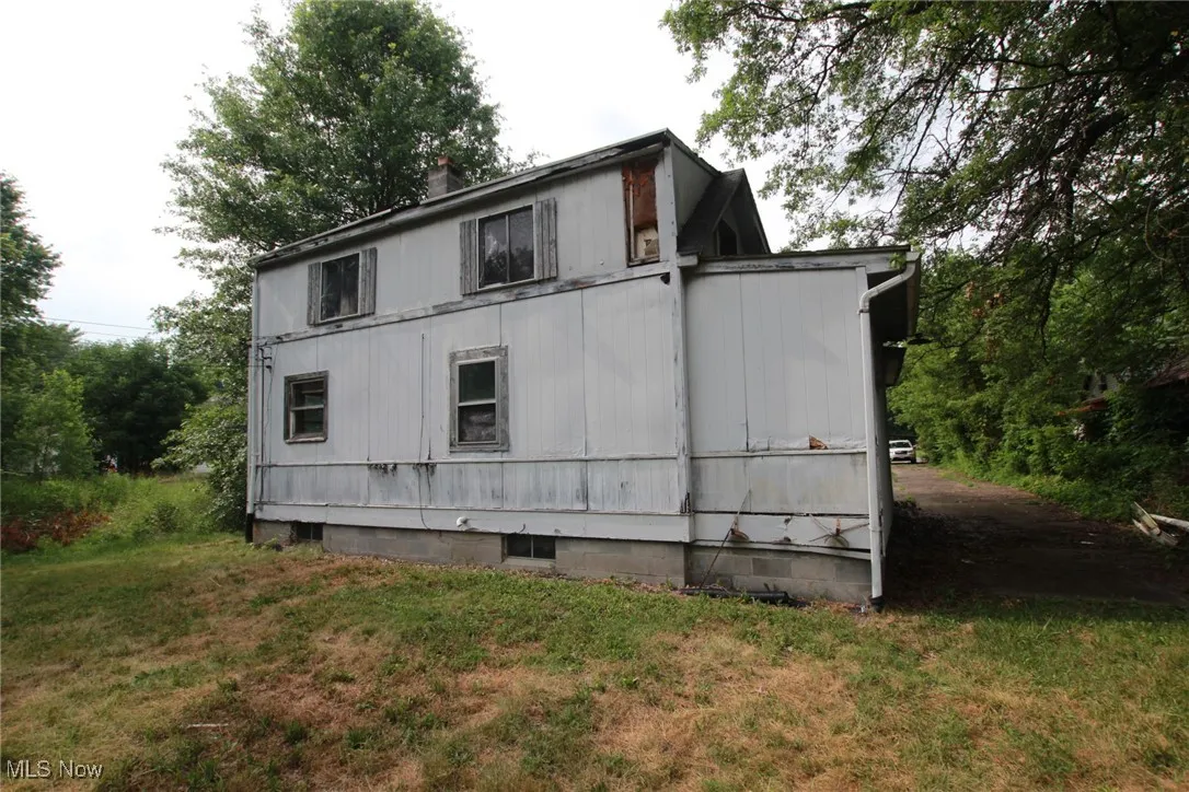 View of side of home featuring a lawn