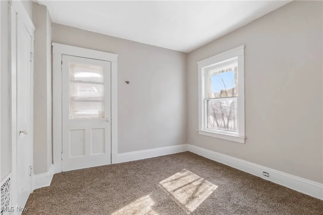 Empty room with carpet flooring and baseboards