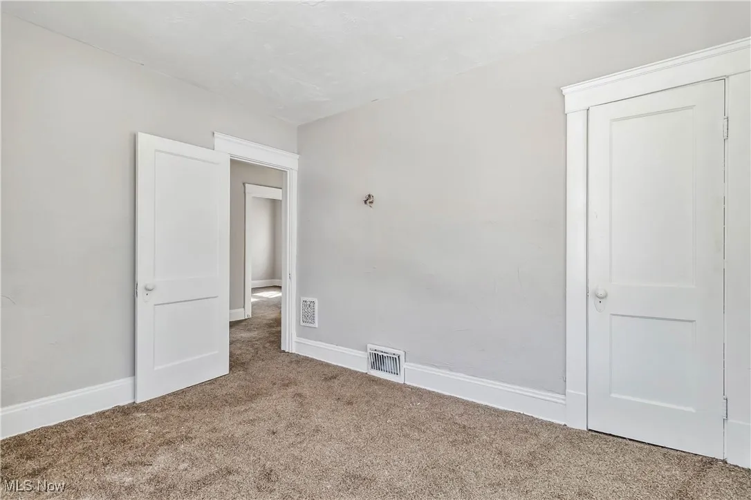 Unfurnished bedroom featuring baseboards, visible vents, and carpet flooring