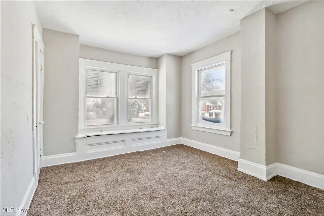 Carpeted empty room featuring baseboards