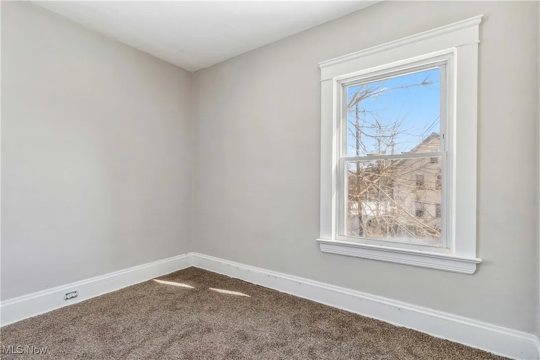 Carpeted spare room with baseboards