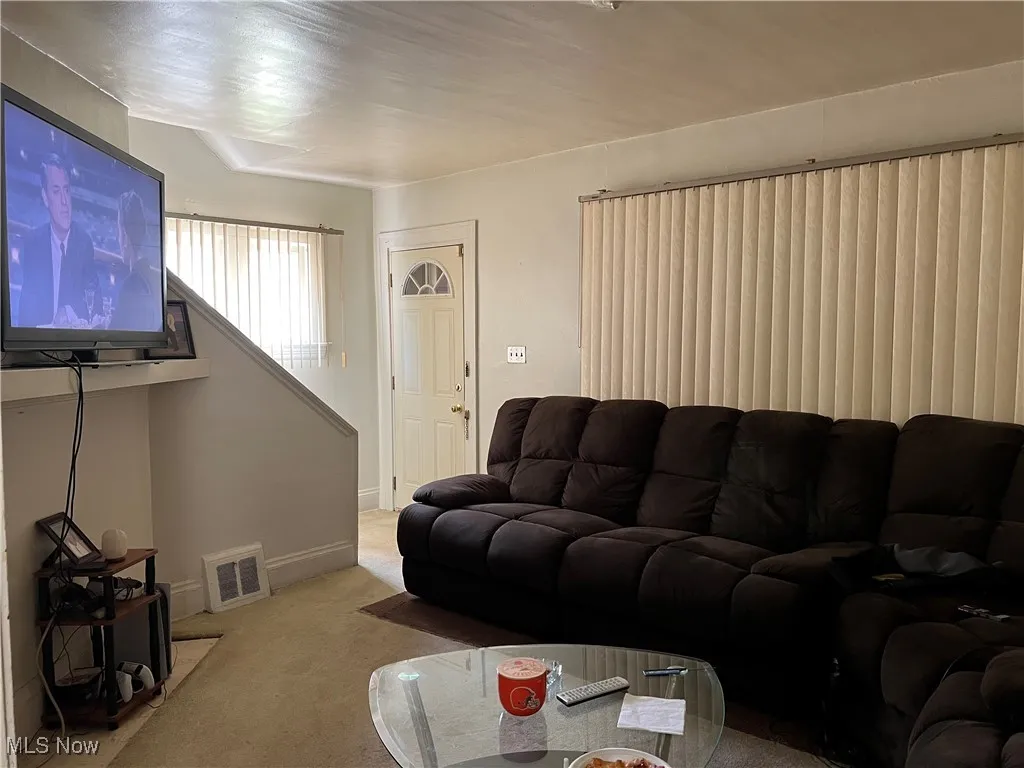 Carpeted living area featuring baseboards