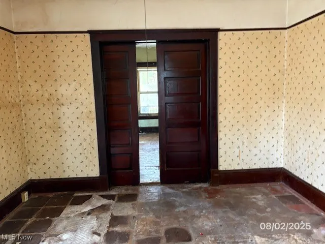 Entrance foyer with wallpapered walls and baseboards