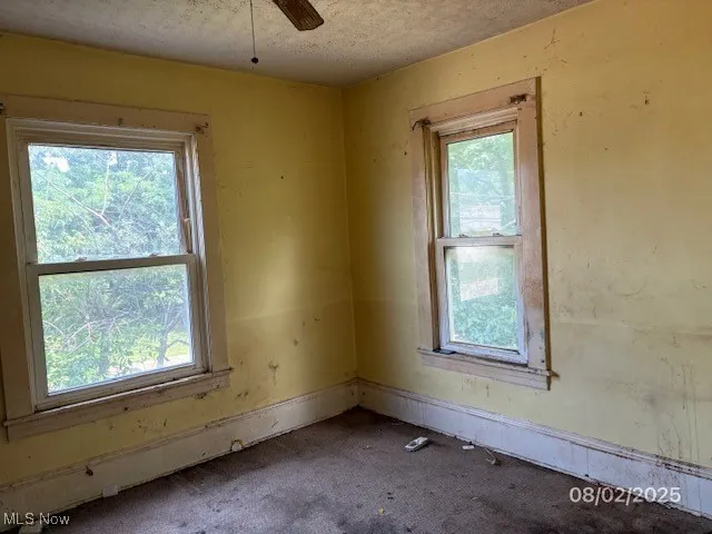 Spare room featuring ceiling fan and a textured ceiling