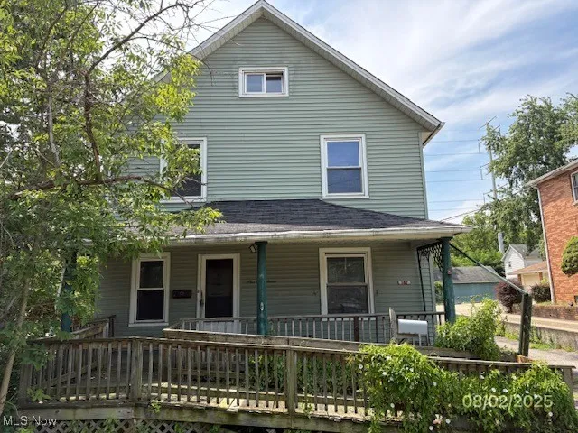 View of front of house featuring covered porch and roof with shingles