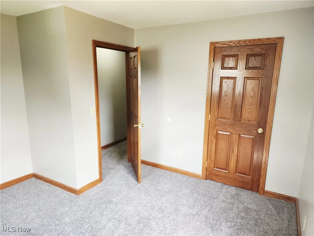 Unfurnished bedroom featuring carpet flooring and baseboards