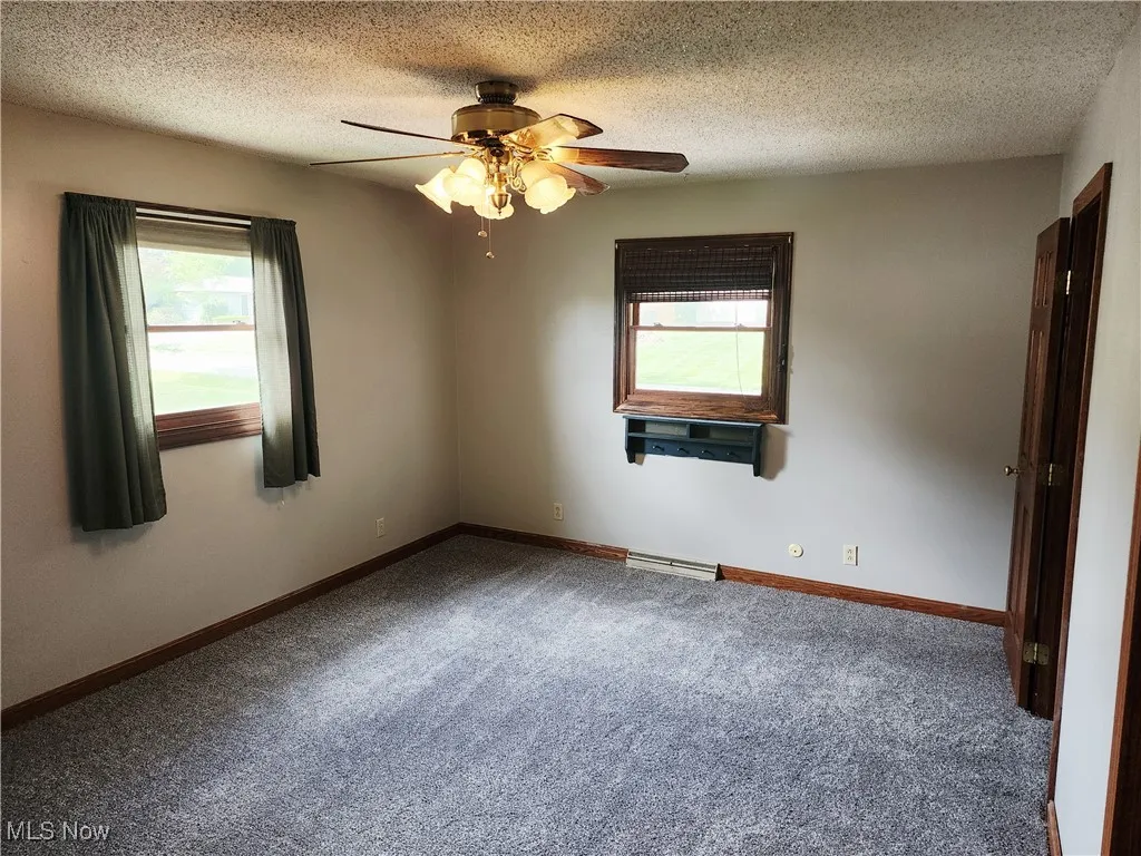 Empty room featuring plenty of natural light, carpet floors, a textured ceiling, and a ceiling​​‌​​​​‌​​‌‌​‌‌​​​‌‌​‌​‌​‌​​​‌​​ fan