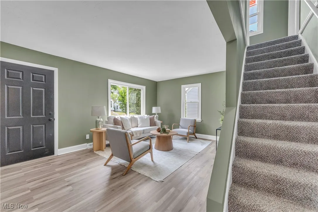 Living area featuring stairs and light wood-style flooring