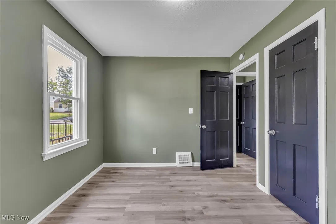 Unfurnished bedroom with light wood-style floors and baseboards
