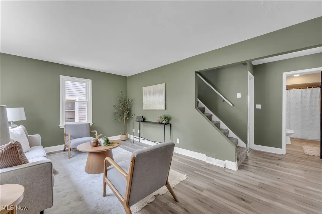 Living area with wood finished floors and stairway