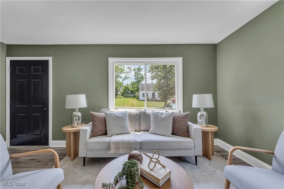 Living area with light wood-style flooring and baseboards