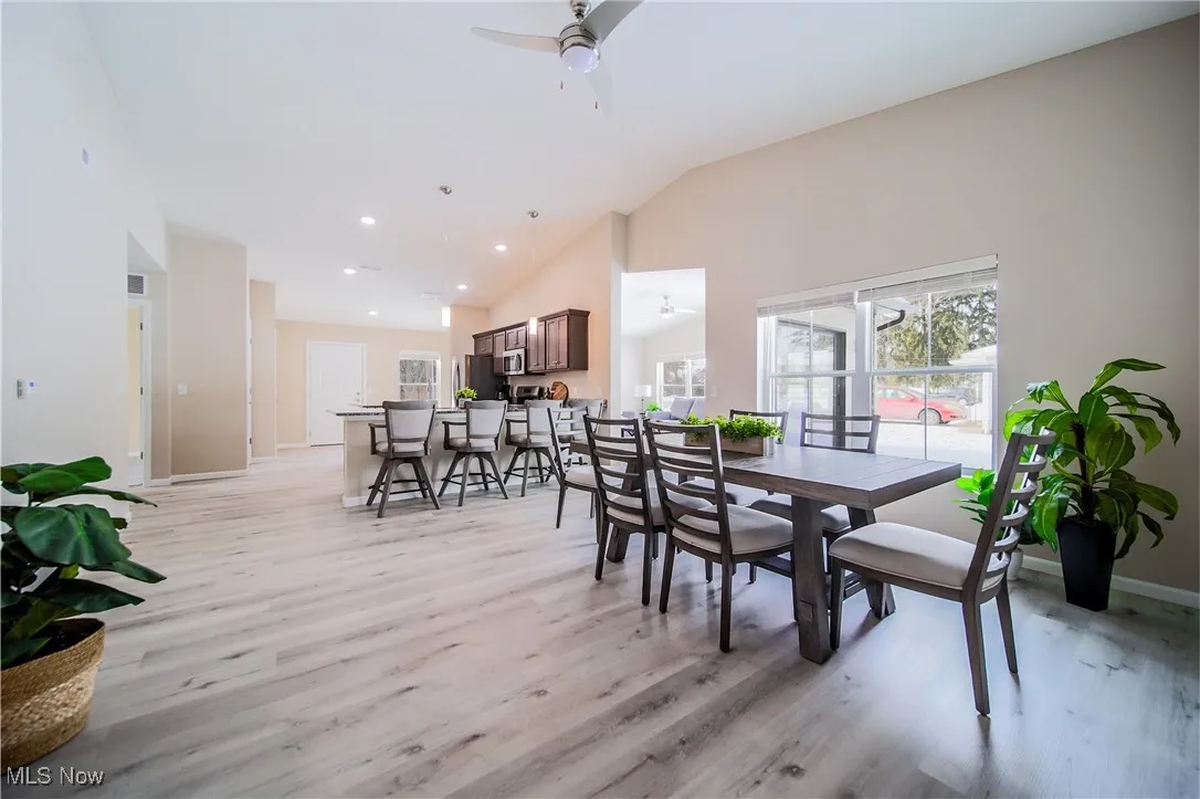 Dining space with a ceiling fan, light wood-type flooring, recessed lighting, and high vaulted ceiling