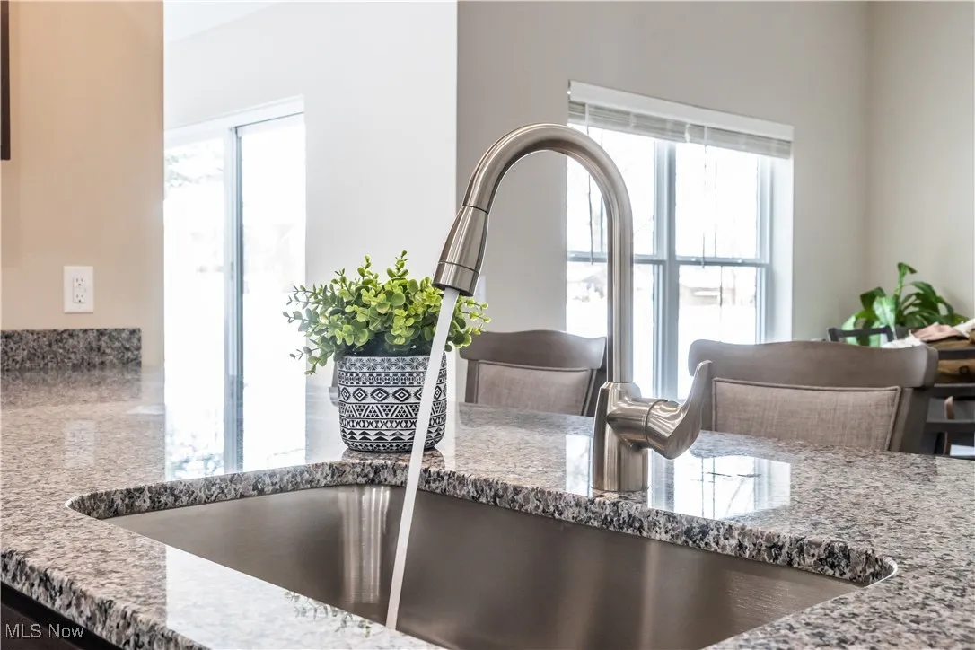 Kitchen view of a sink and stone countertops