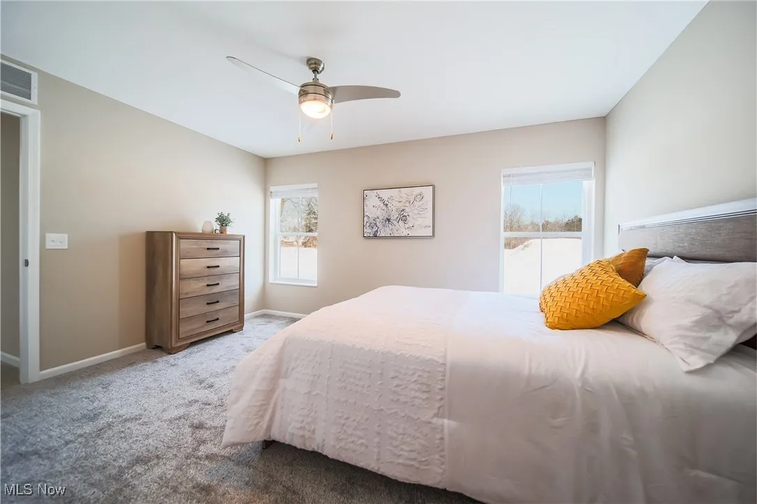 Carpeted bedroom featuring baseboards and ceiling fan