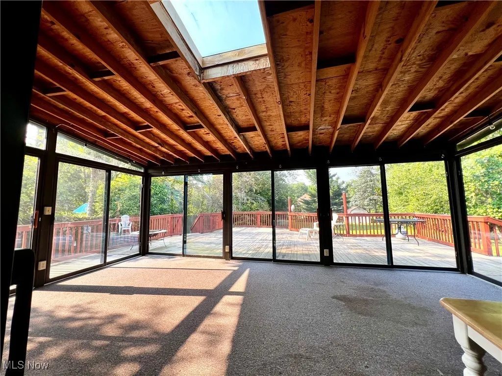 Unfurnished sunroom with a skylight.