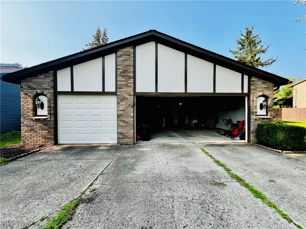 Three car garage featuring concrete driveway