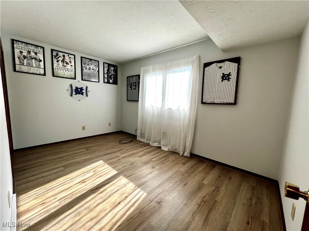 First floor bedroom featuring a textured ceiling and luxury vinyl