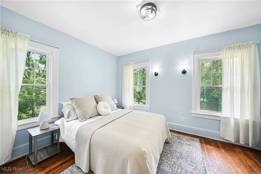 Bedroom featuring hardwood / wood-style floors and multiple windows