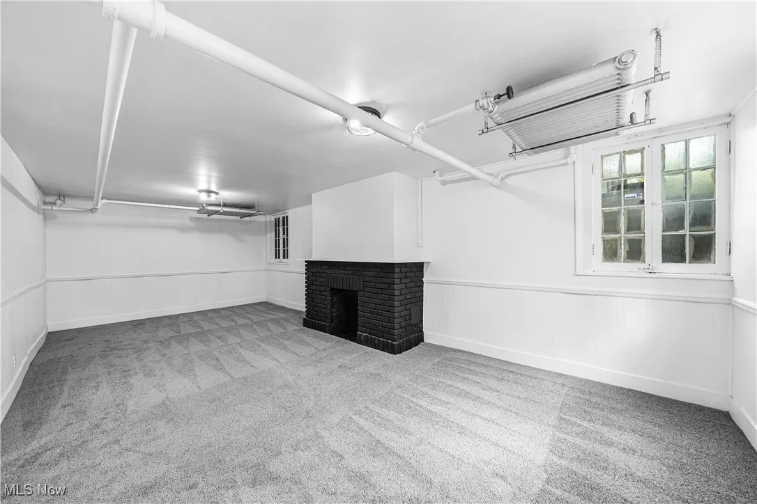 Below grade area featuring wainscoting, a fireplace, carpet flooring, and wood walls